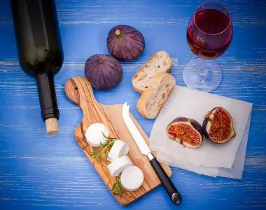 Botellas de vino blanco, tinto y rosado con copas en una mesa, representando una variedad de opciones para disfrutar de vinos bajos en carbohidratos en una dieta cetogénica